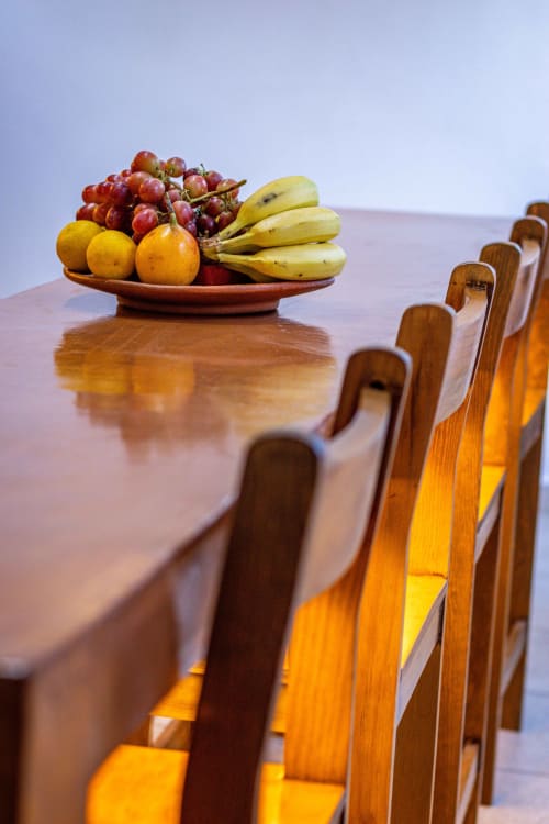 Mesa de comedor de madera en Casa Sofi Oaxaca con frutero fresco y sillas, lista para recibir huéspedes