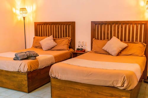 Dos camas individuales con ropa de cama naranja en una habitación luminosa de Casa Sofi Oaxaca, México