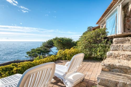 Chaises longues blanches sur la terrasse surplombant la mer Méditerranée aux Finques Garcia Enrich, Palafrugell