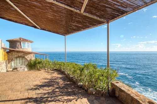 Terrasse côtière avec vue méditerranéenne, bâtisse en pierre et pergola ombragée aux Finques Garcia Enrich, Palafrugell