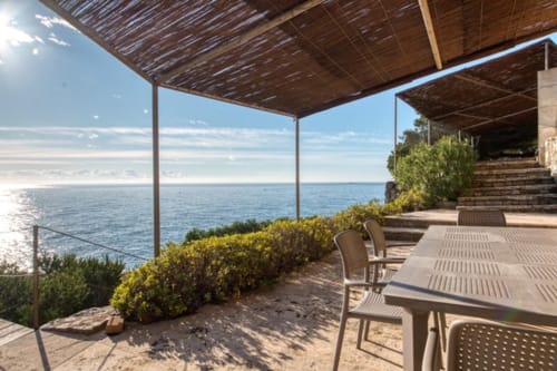 Terrasse en bord de mer de Finques Garcia Enrich à Palafrugell avec table de repas, pergola ombragée et vue sur la mer Méditerranée