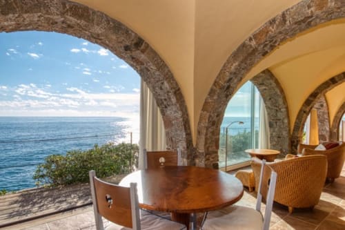 Salle à manger côtière avec voûtes en pierre et vue sur la mer à Finques Garcia Enrich, Palafrugell
