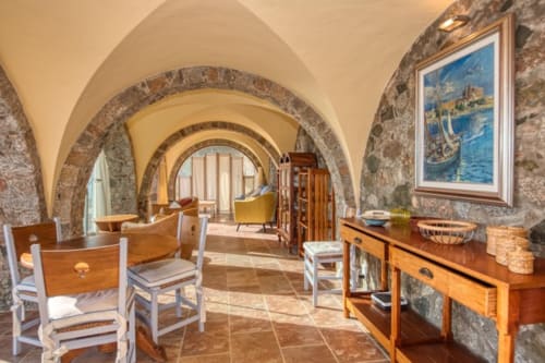 Couloir voûté en pierre avec mobilier rustique et œuvres d'art méditerranéennes à Finques Garcia Enrich, Palafrugell