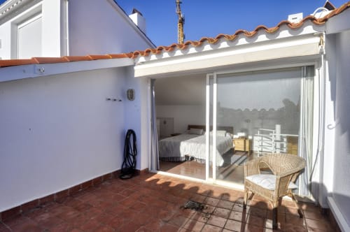 Assolellada terrassa amb cadira de vímet a l'hotel Finques Garcia Enrich de Palafrugell, Espanya