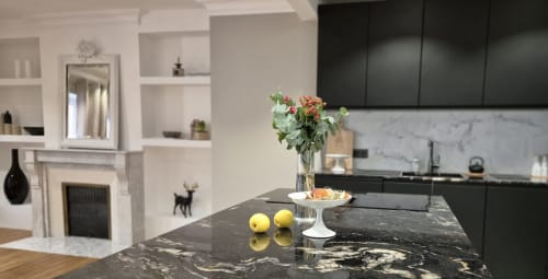 Moderne keuken in Maison Lùisa op Moulin Renaudiots, Autun, met zwart marmer eiland, verse bloemen en zwarte kasten