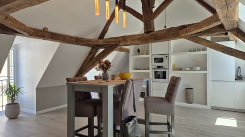 Modern loft-appartement in Moulin Renaudiots met zichtbare houten balken, eethoek en witte keukenkasten