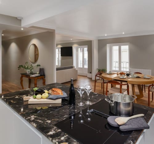 Modern keuken- en eetgedeelte in Maison Lùisa in Autun met zwart marmeren werkblad, houten eettafel en stadsuiticht