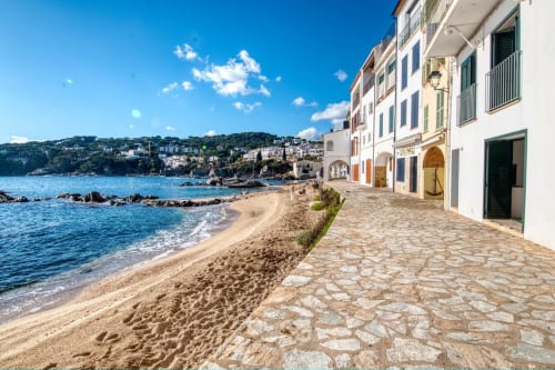 Edificis davant la costa mediterrània de Palafrugell amb platja de sorra i mar blau turquesa