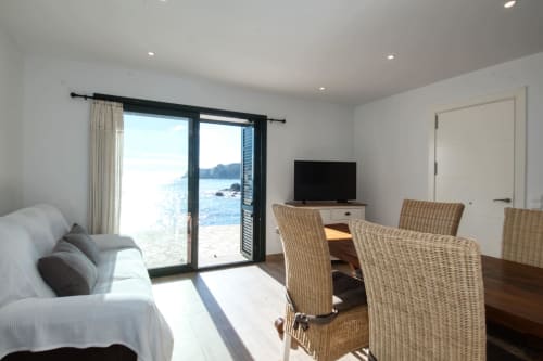 Suite de dormitori lluminosa a Finques Garcia Enrich amb vistes al mar, cadires de vímet i terrassa amb vista a la costa de Palafrugell