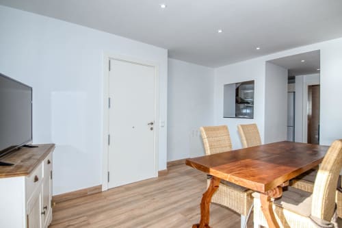 Menjador modern a l'hotel Finques Garcia Enrich a Palafrugell amb taula de fusta, cadires de vímet i estil contemporani