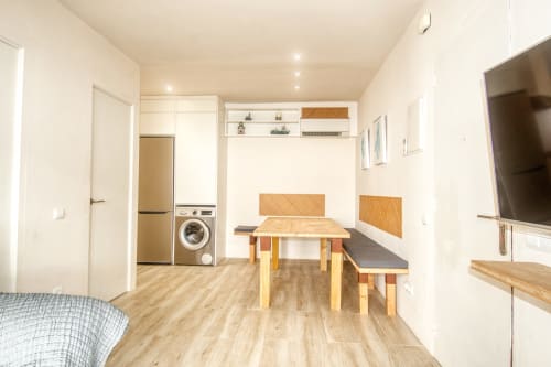 Modern studio at Finques Garcia Enrich featuring kitchenette, dining table, TV, washing machine, and wooden flooring in