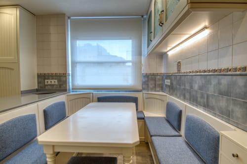 Rincón de cocina moderno con asiento tapizado azul en Finques Garcia Enrich, Palafrugell