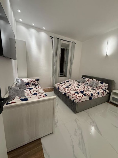Camera moderna del St Mary Major Loft Roma con letti gemelli, biancheria grigia, illuminazione incassata e pavimenti in marmo