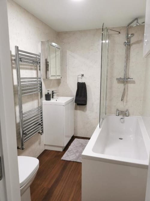 Spacious bathroom with a bathtub in seasky appartment - four bedroom house in Portland