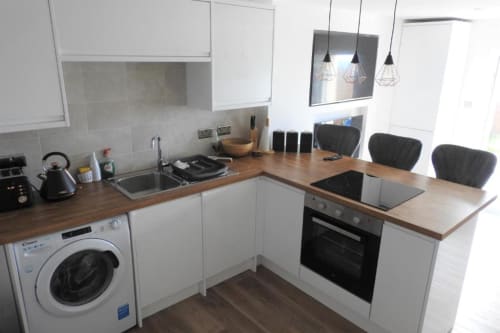 Equipped kitchen, dining area with washing machine and electric oven in The cuddy appartment in Portland