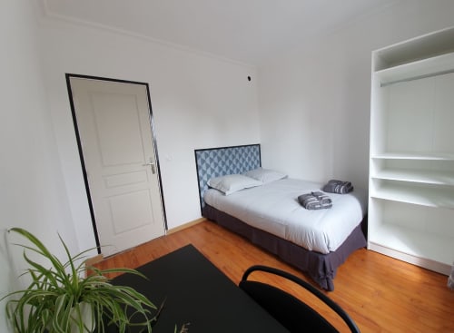 Chambre lumineuse à la NancyRoom B&B à Vandœuvre-lès-Nancy avec lit double, étagères blanches, parquet et vue sur la ville
