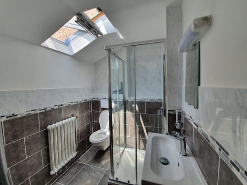 Salle de bain moderne de la Chambre B à NancyRoom à Vandoeuvre-les-Nancy avec douche, toilettes, lavabo et puits de lumière