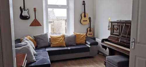 cozy living room with piano and large sofa in seasky appartment - four bedroom house in Portland