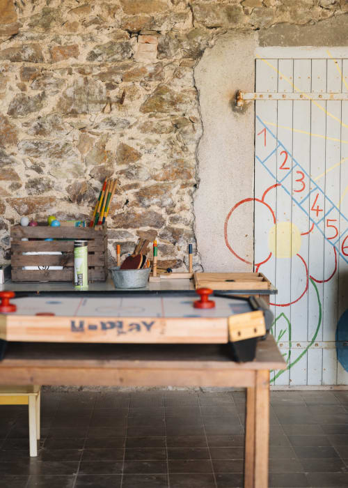 Espace créatif à La Maison D'olivier B&B avec mur en pierre brute, fournitures artistiques et tableau pédagogique à Mesnard La