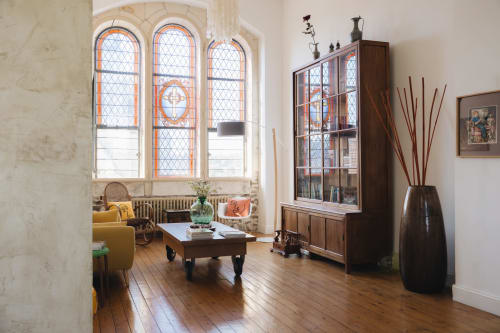 Élégant séjour de La Maison D'olivier BnB à Mesnard la Barotière avec fenêtres cintrées, mobilier en bois et style d'époque