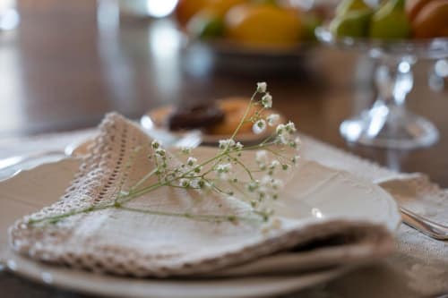Elegante mise en place a Villa Ceci B&B ad Andria con delicato tovagliolo bianco, fiori di gelsomino e apparecchiatura