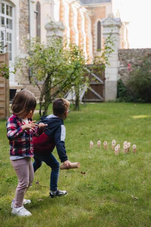 Des enfants jouent à des jeux de jardin dans la cour de La Maison D'olivier, une maison d'hôtes française à Mesnard la