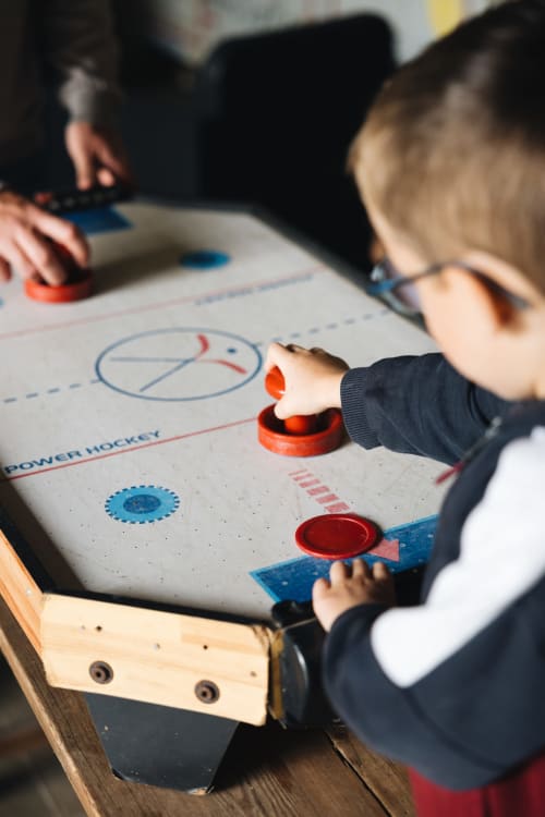 De jeunes hôtes profitent du hockey sur table à La Maison D'olivier B&B à Mesnard La Barotière