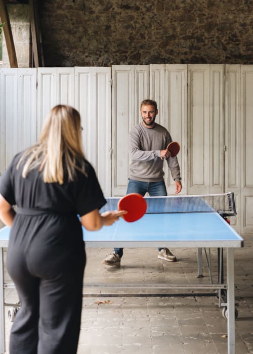 Deux clients jouant au tennis de table à La Maison D'olivier, un gîte français à Mesnard la Barotière