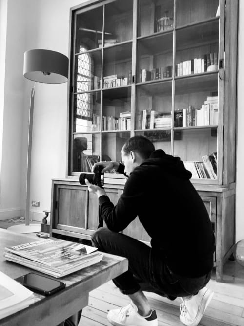 Homme photographiant une bibliothèque à La Maison D'olivier, boutique hôtel à Mesnard La Barotière, France
