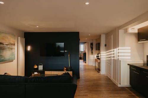 vue du séjour lumineux de L'alcôve Clisson et son mur cube bleu