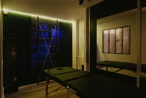 vue de l'espace coquin de L'alcôve clisson avec sa table de massage et sa croix de Saint-André