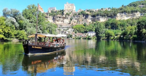 Traditional riverboat cruises past medieval castle in Dordogne, near Carsac-Aillac accommodation