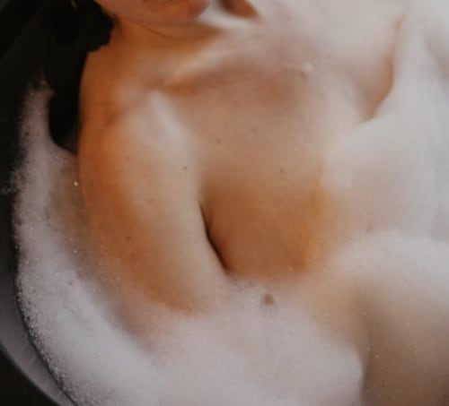 photo sensuelle d'une femme prenant un bain de mousse