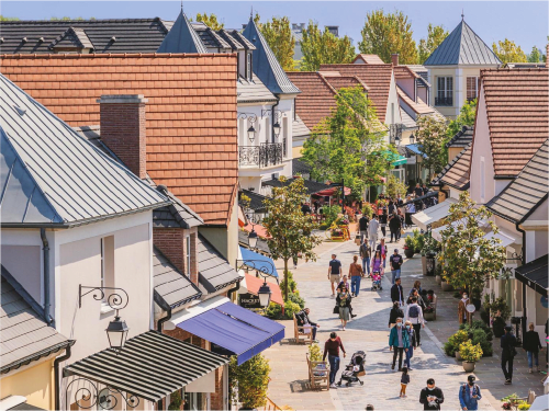 Vue aérienne de la Résidence Disneyland Place Toscane à Serris avec bâtiments de style européen, esplanade piétonne et visiteurs