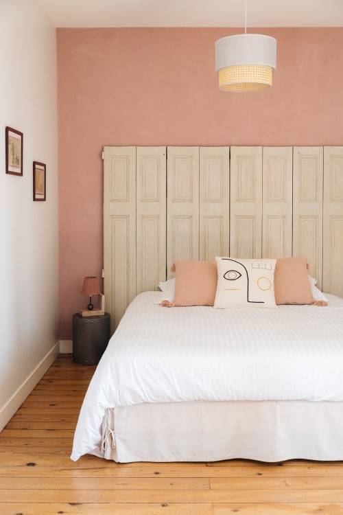 Chambre cosy de La Maison D'olivier avec mur pêche, armoire crème et literie blanche
