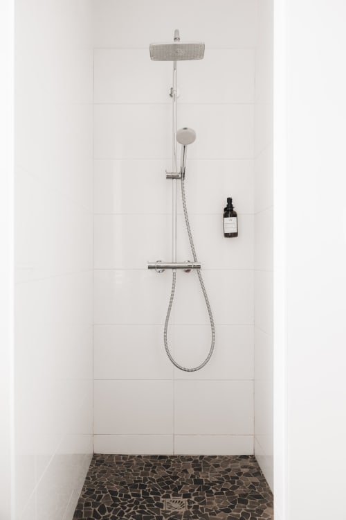 Salle de bain moderne à La Maison D'olivier avec pluie de douche, douchette manuelle et sol en pierre noire