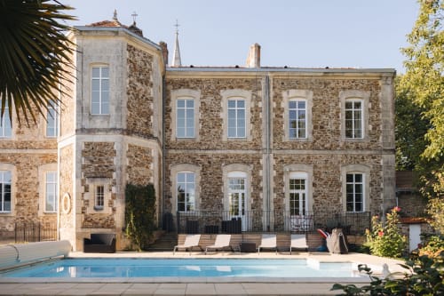 L'hôtel La Maison D'olivier avec son architecture en pierre, sa piscine et ses transats à Mesnard La Barotière