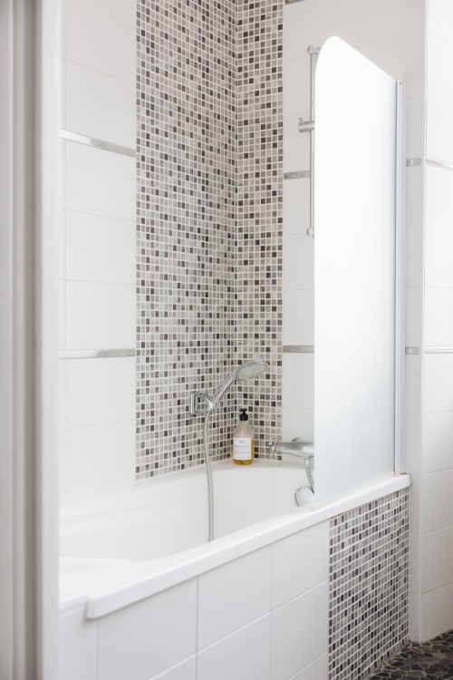 Salle de bains moderne avec mur d'accent en carrelage mosaïque, carreaux de métro blancs, baignoire avec paroi vitrée à La Maison D'olivier,