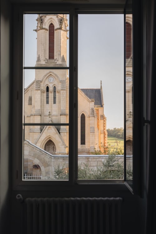 Vue de la tour de l'église historique et des bâtiments en pierre depuis la fenêtre de La Maison D'olivier, Mesnard La Barotière France