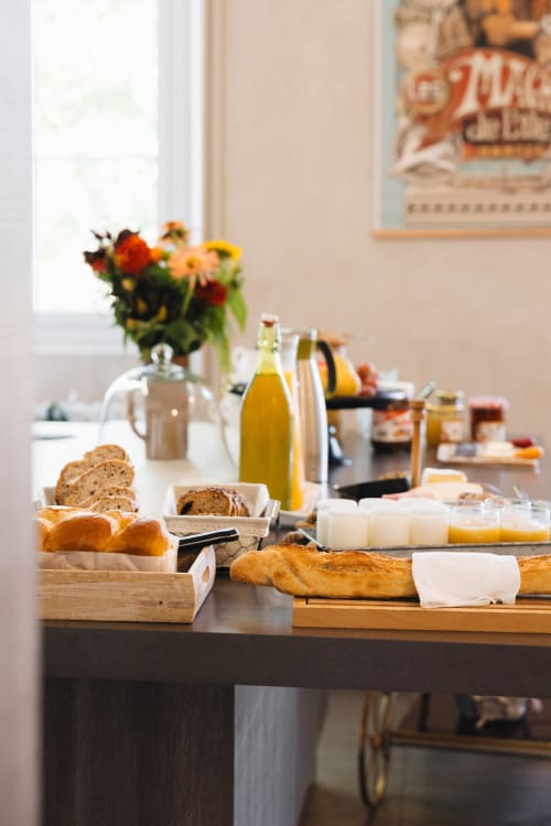 Petit-déjeuner français à La Maison D'olivier avec pain frais, viennoiseries, fromage et fleurs
