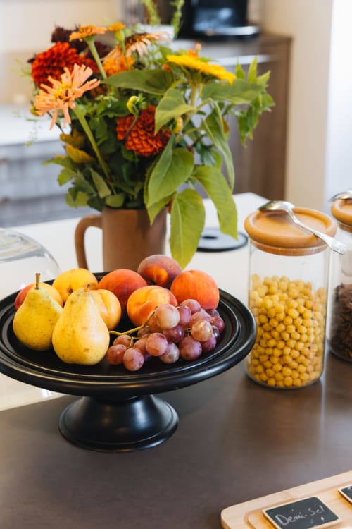 Table élégante avec fruits frais, fleurs et produits de la maison d'hôtes La Maison D'olivier