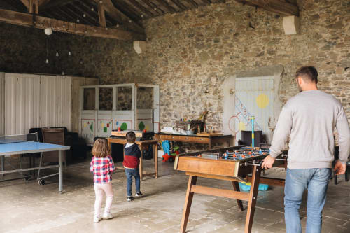 Salle de jeux familiale à La Maison D'olivier avec baby-foot, ping-pong et jeux en bois dans une ferme française rustique
