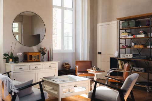 Élégant séjour de la Maison D'olivier avec miroir rond, mobilier crème et décor moderne à Mesnard la Barotière