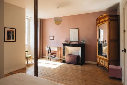 Chambre spacieuse à La Maison D'olivier B&B avec parquet, murs roses, mobilier vintage et lumière naturelle
