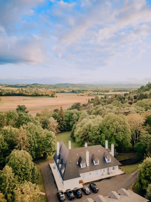 Luftaufnahme des Herrenhauses Domaine de Bize in Mirepoix, Frankreich, umgeben von Wald und Agrarland