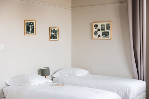 Chambre chaleureuse à La Maison D'olivier B&B à Mesnard La Barotiere avec lits jumeaux, photos vintage et décoration moderne