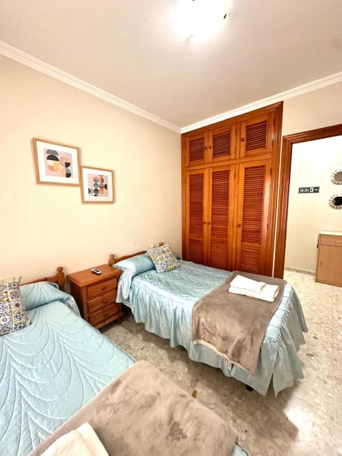 Amplio apartamento de tres dormitorios en Mérida con armarios de madera, camas individuales y vistas a la ciudad