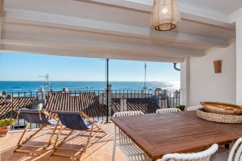 Beachfront terrace at Finques Garcia Enrich in Palafrugell with dining table, loungers, and Mediterranean sea views