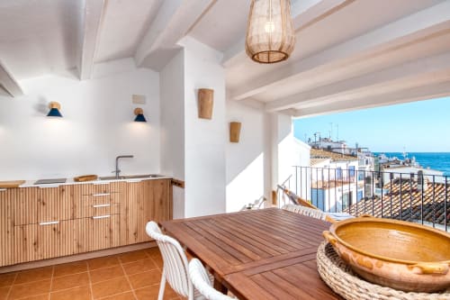 Modern coastal kitchen-dining area with wooden furnishings, sea views, and terrace at Finques Garcia Enrich, Palafrugell