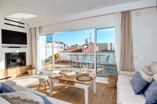 Bright modern living room with fireplace, sea views, and terrace in Palafrugell hotel